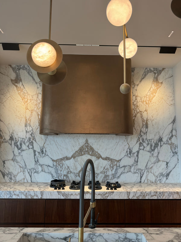 Metal plaster kitchen hood framed by marble