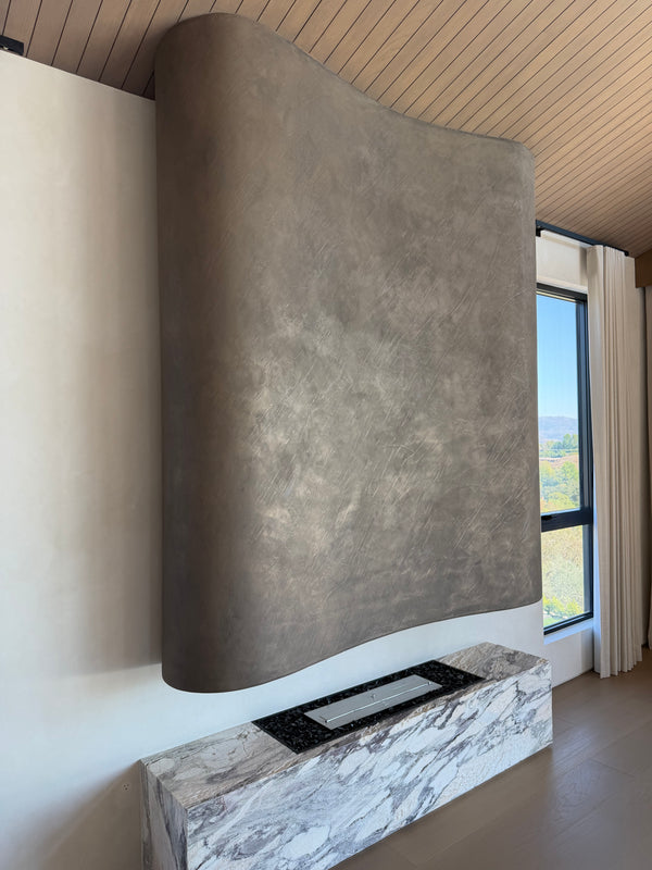 Sculptural fireplace with a hand-applied metal plaster finish